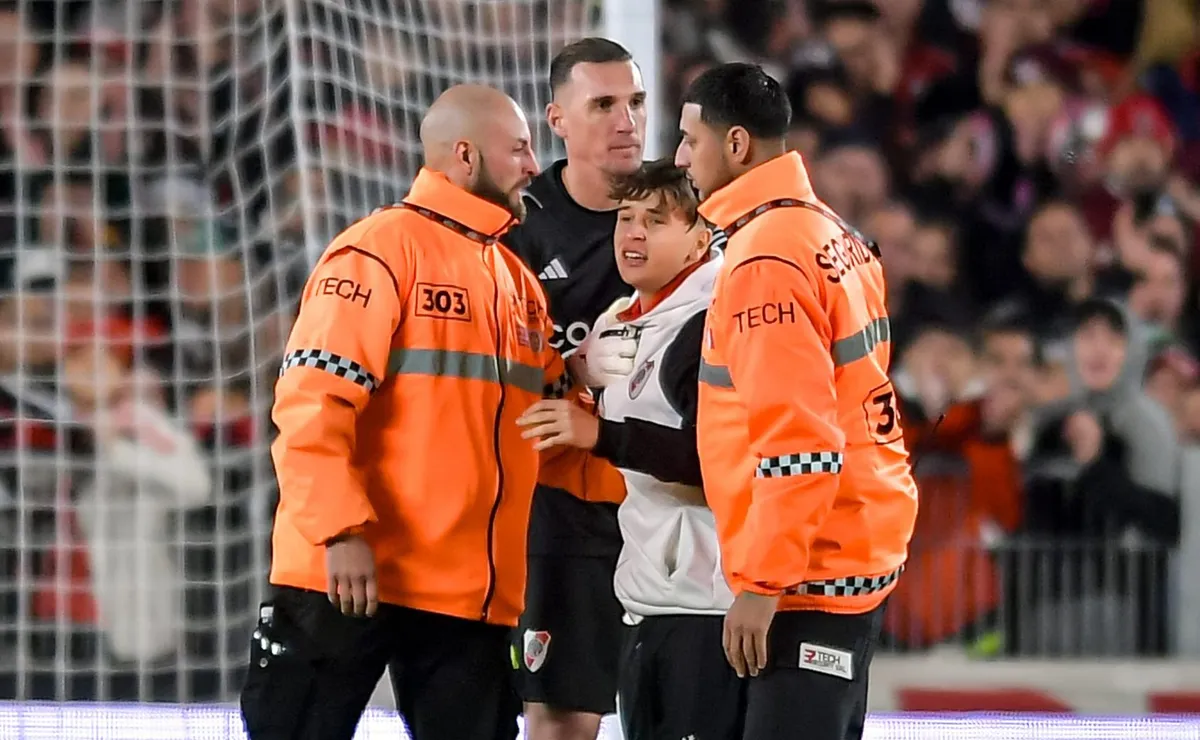 Armani junto al chico que se metió al campo.