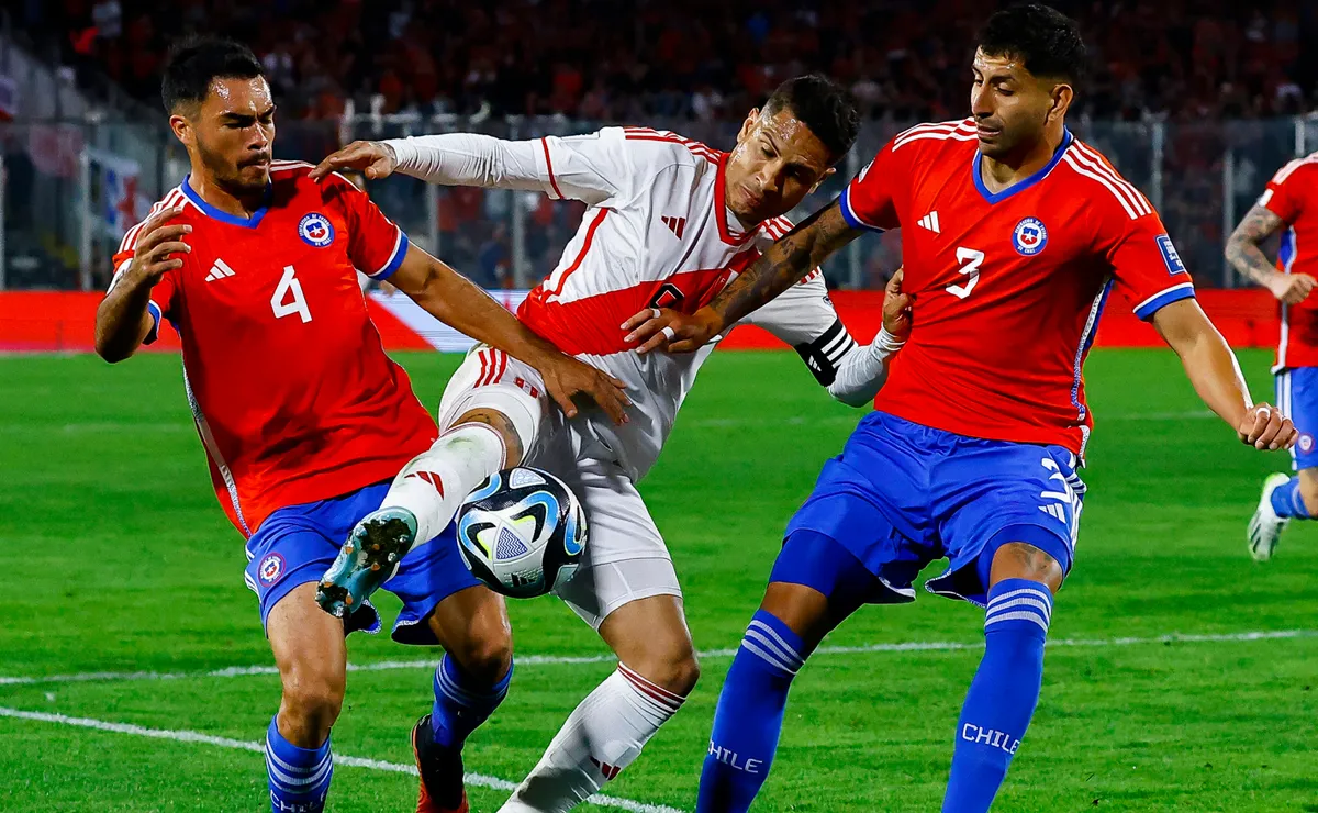 Paolo Guerrero, de Perú, lucha contra dos rivales chilenos.