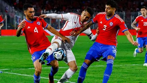 Paolo Guerrero, de Perú, lucha contra dos rivales chilenos.