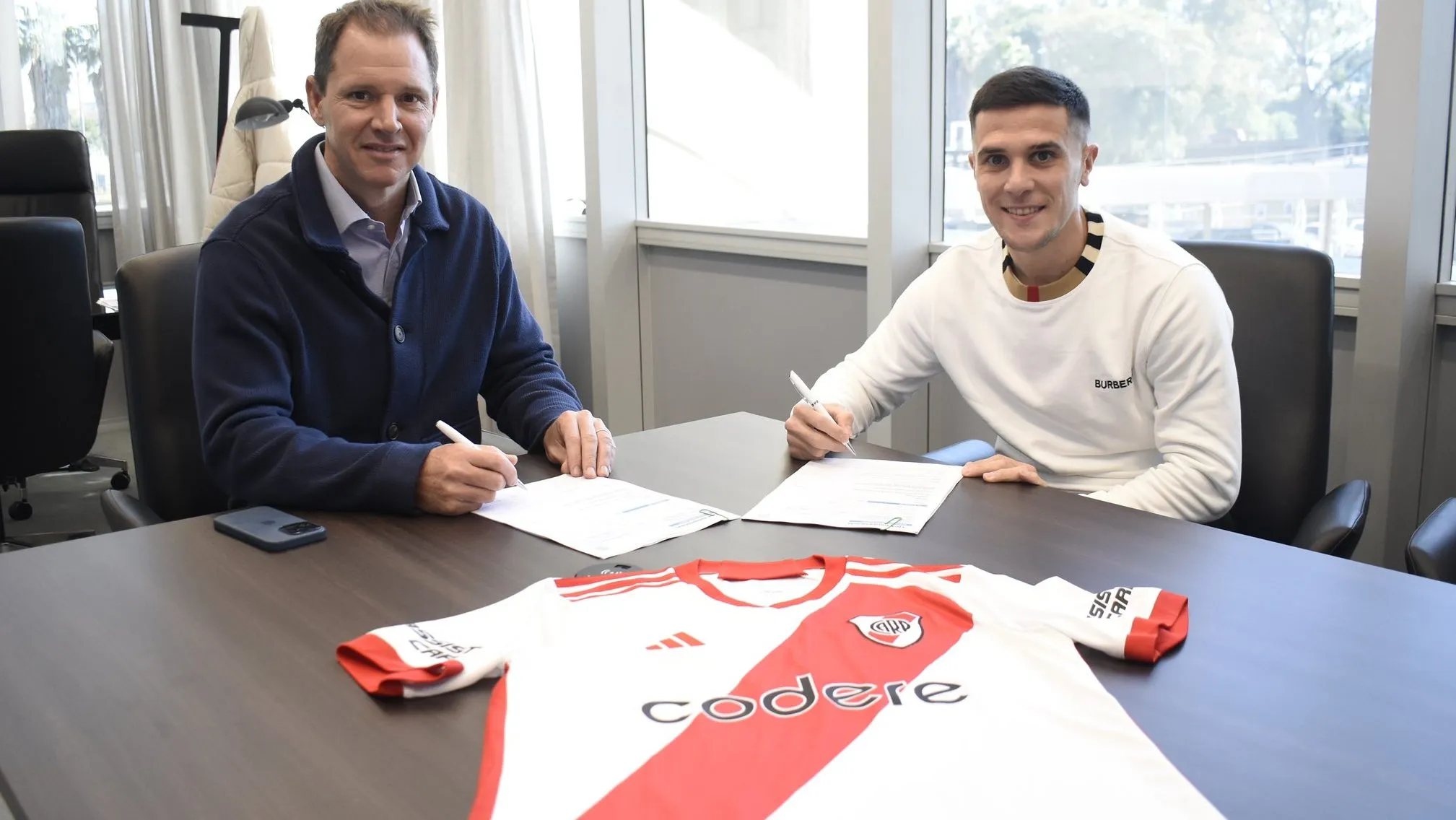 Bustos firmó su contrato acompañado del presidente Jorge Brito. (Foto: Prensa River).