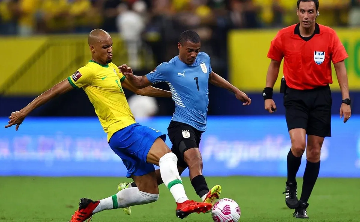 De La Cruz ante la marca de Fabinho en el último Uruguay vs. Brasil por Eliminatorias.