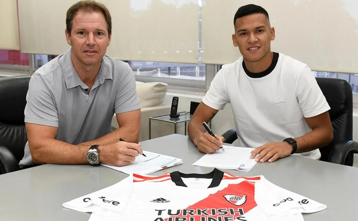 Andrés Herrera firma su contrato con River junto al presidente Jorge Brito.