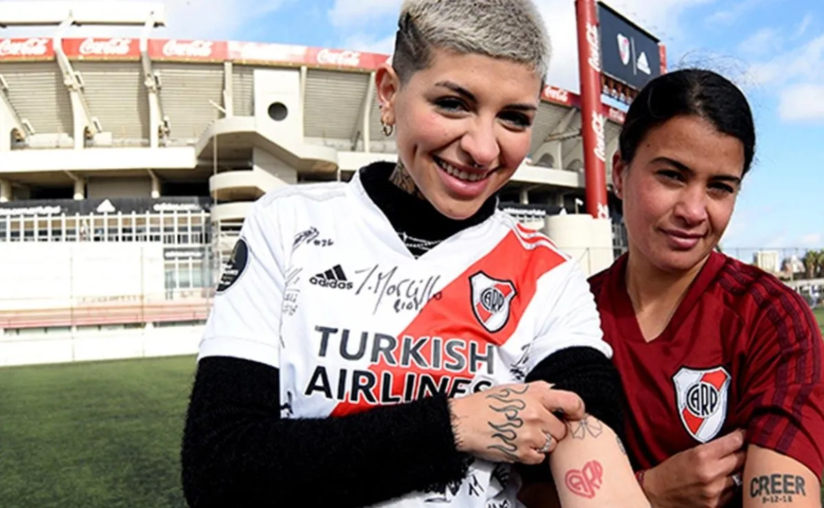 Cazzu junto a Carolina Birizamberri, ambas muestran sus tatuajes riverplatenses.