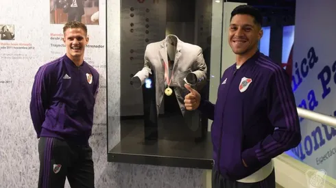 Zuculini y Enzo Pérez posando frente al saco de Gallardo, en una visita al Museo.