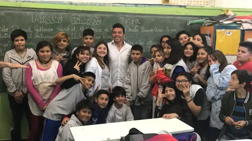 Gallardo y varios estudiantes en una de las aulas de la escuela N° 12 de Merlo.