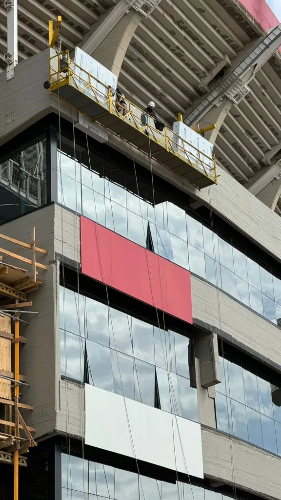 Colocación de las placas de aluminio rojas y blancas en la fachada de la Sívori.