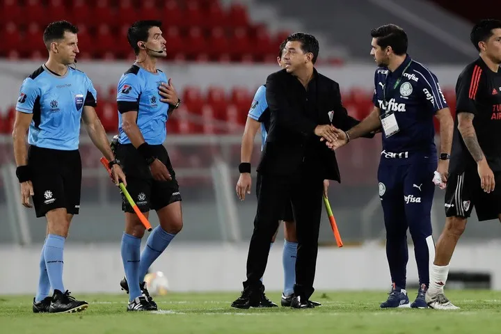 Ferreira va a saludar a Gallardo mientras el Muñeco le reclama algo al árbitro, tras el 0-3 en Avellaneda.