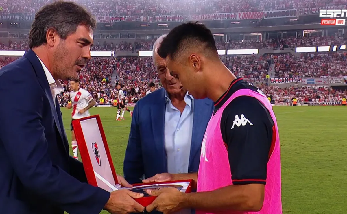 Andrés Ballotta, vicepresidente 1° de River, le entrega la plaqueta a Pity Martínez a modo de reconocimiento.